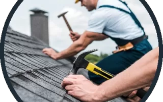 Roofers nailing in shingles on a roof