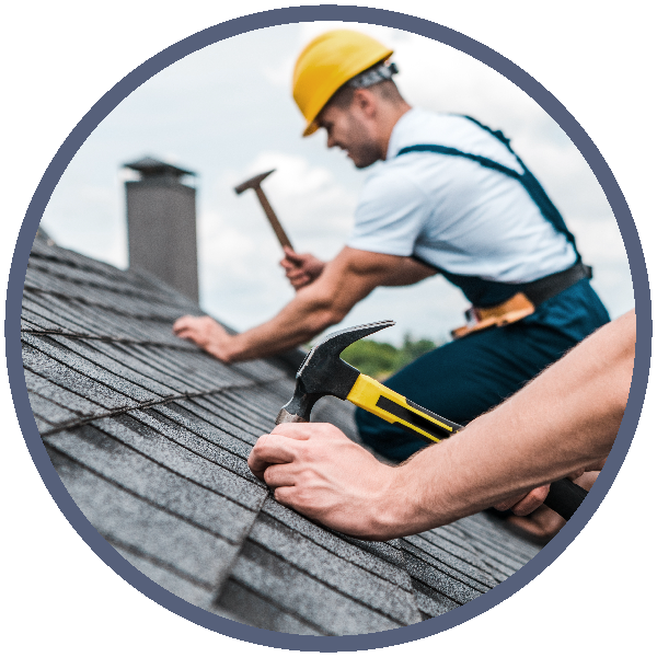 Roofers nailing in shingles on a roof